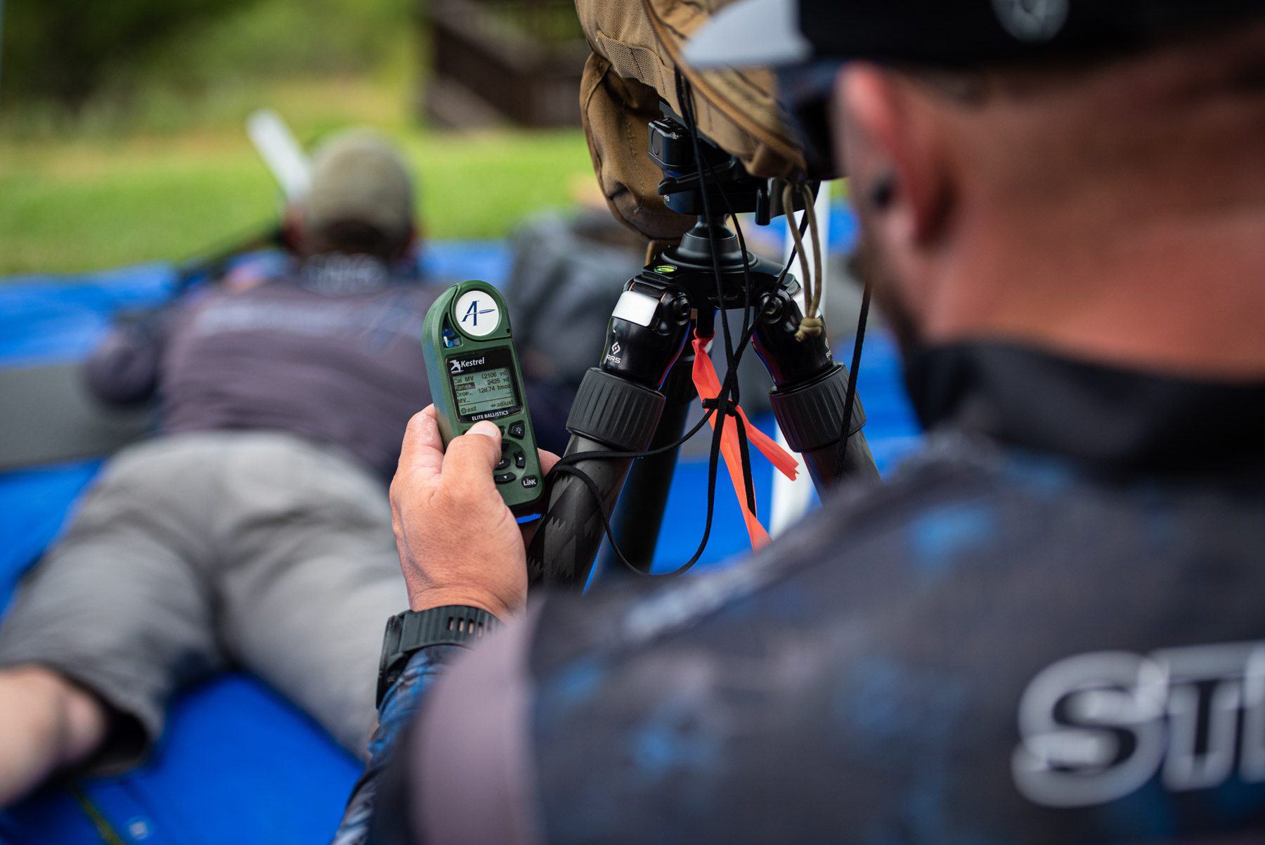 Chase Stroud gets ballistics data off of his Kestrel ballistics and weather meter at an ELR competition in Texas, Conquer the Castle Man holding a Kestrel Ballistics meter at an ELR competition in Texas